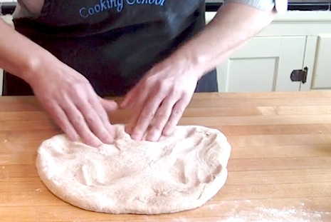 Whole Wheat Pizza Dough being stretched